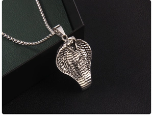 Macro shot of cobra head pendant featuring detailed scales and vintage punk style metalwork