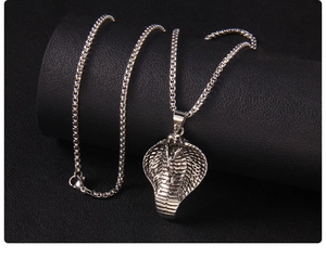 Macro shot of cobra head pendant featuring detailed silver scales and a gothic box chain