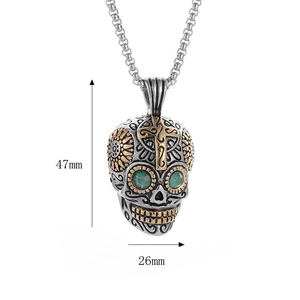 Macro shot of punk skull necklace with green gem eyes and golden floral details