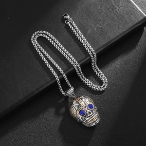 Punk vintage stainless steel skull necklace with blue gemstone eyes on black leather background