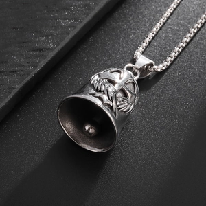 Vintage stainless steel guardian bell with wing and cross engraving on a box chain