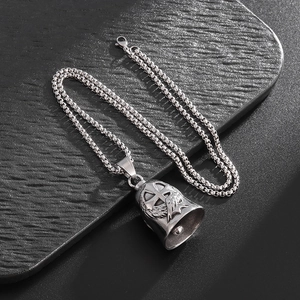 Detailed relief of cross and feather wings on a vintage steel motorcycle bell pendant