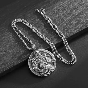 Vintage stainless steel Viking Odin pendant necklace on a textured black stone background