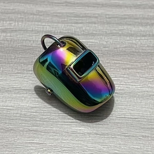 Pendentif casque de soudage en métal arc-en-ciel poli sur une surface en bois