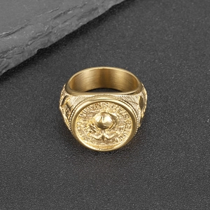 Gold stainless steel US Marine Corps eagle ring shown on dark stone background