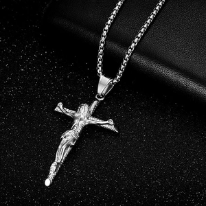 Polished stainless steel crucifix cross pendant with box chain on dark textured background