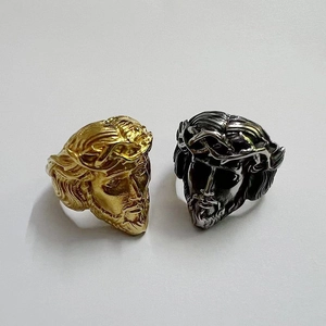 Macro detail of polished stainless steel Jesus Christ portrait rings in gold and black