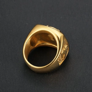 Gold-plated stainless steel men's signet ring with detailed eagle relief on a dark background