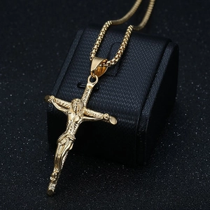 Gold crucifix pendant necklace with box chain displayed on a professional jewelry stand