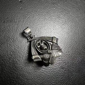 Detailed close-up of a stainless steel grim reaper pendant with scythe on leather