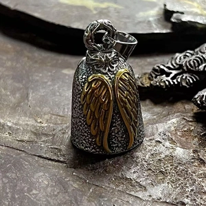 Détail d'une cloche de moto vintage avec des ailes d'ange dorées et texture de roche