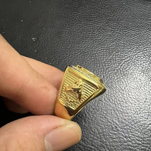 Macro view of gold-plated stainless steel eagle ring with detailed side embossing