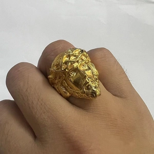 Macro detail of gold plated stainless steel ring featuring an embossed Jesus portrait