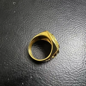 Macro shot of gold-plated eagle ring showing detailed side relief patterns and texture