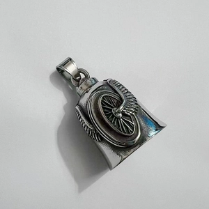 Detailed close-up of a stainless steel biker guardian bell with wing and wheel motifs