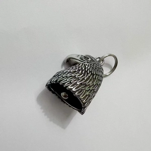 Macro view of vintage eagle head bell pendant with detailed feather textures
