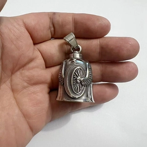 Macro view of vintage stainless steel guardian bell with wing wheel motifs on palm