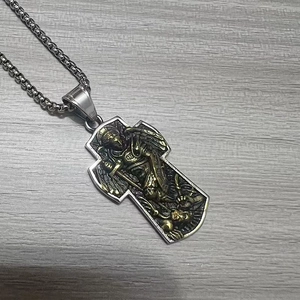 Détail du pendentif croix Archange Saint Michel aux tons or et argent vintage