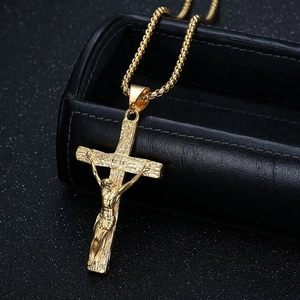 Gros plan d'un pendentif crucifix doré avec texture sur une boîte en cuir noir
