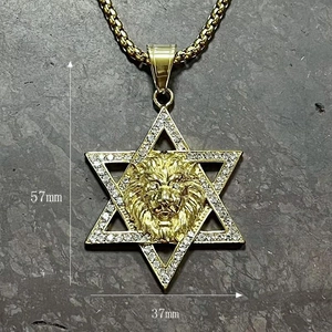 Détail du pendentif étoile tête de lion doré avec dimensions 57mm sur 37mm sur fond roche