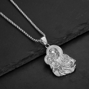 Detailed macro shot of an engraved Holy Family pendant on a heavy silver box chain