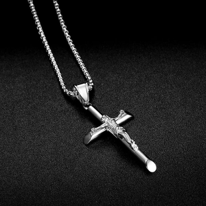 Collier avec pendentif crucifix en acier inoxydable argenté sur fond noir texturé