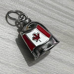 Detailed macro view of vintage stainless steel bell keychain with red Canada maple leaf