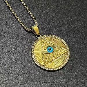 Détail macro du collier pendentif œil de la providence doré avec zircons blancs
