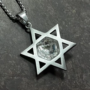 Gros plan sur un pendentif Étoile de David en acier argenté et centre en cristal