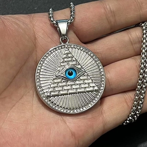 Détail macro du pendentif œil de pyramide doré avec pierre bleue et zircons blancs