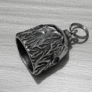 Macro detail of stainless steel motorcycle bell pendant with skull and branch texture
