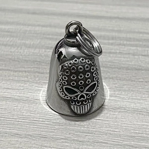 Macro detail of silver stainless steel bell pendant featuring a unique skull dot pattern