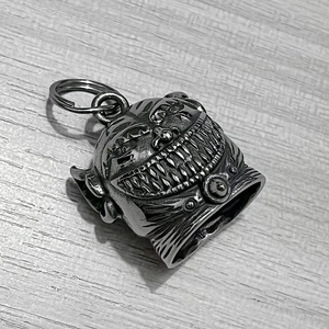 Makro-Detail der Retro polierten Edelstahl Monster-Glocke Anhänger auf Holzoberfläche