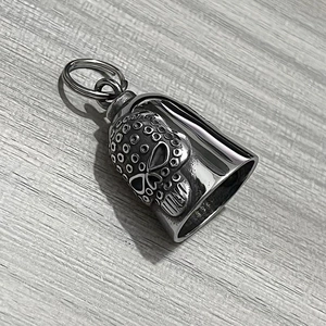 Detailed macro of a polished stainless steel skull embossed guardian bell pendant