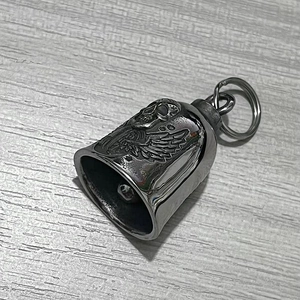 Macro detail of gothic stainless steel bell pendant with skull and wings engraving