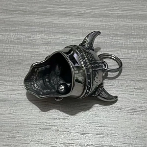 Close-up of vintage stainless steel Viking skull helmet pendant with horns and bell detail