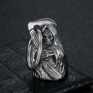 Retro stainless steel Grim Reaper keychain with scythe on black leather texture