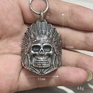 Detailed view of punk style Indian chief skull bell pendant with feather headdress design