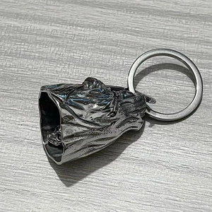 Macro detail of gothic grim reaper bell keychain with skeleton skull in vintage silver finish