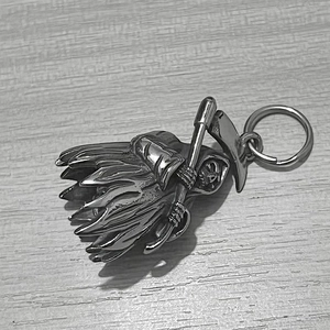 Detailed view of silver grim reaper skull bell pendant with scythe in metallic finish