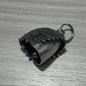 Macro detail of vintage stainless steel motorcycle guardian bell with feather engravings