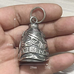Vue détaillée de la cloche de motard en acier avec relief de pistolet et gravure