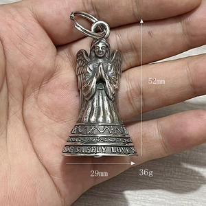 Close-up of vintage stainless steel angel prayer bell keychain with engraved safety message