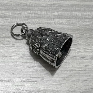 Macro shot of stainless steel bell pendant with detailed flame relief and vintage finish