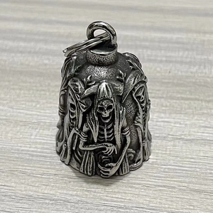 Detail of gothic stainless steel bell with grim reaper and skull embossed engravings