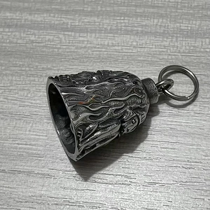 Macro shot of retro stainless steel bell with flame relief and metallic keyring attachment