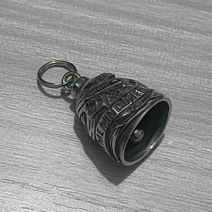 Détail d'une clochette de motard en acier inoxydable avec gravure Remind Me sur bois