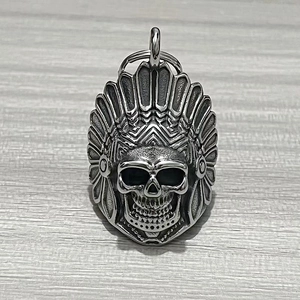 Detailed close-up of a stainless steel Indian chief skull bell pendant on wood