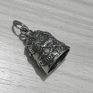Detailed macro of vintage silver guardian bell with embossed ride to text and biker eagle