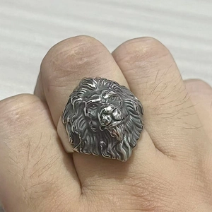 Detailed close-up of retro lion head ring in vintage finish stainless steel on finger